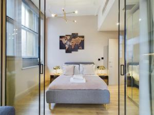 a bedroom with a bed and a glass wall at Luxury Unique 2bedroom city centre in Manchester