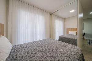 a bedroom with two beds and a mirror at Elyseés Residencial Flipchave ELY000 in Joinville +48 photos