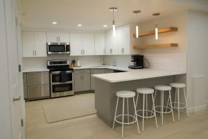 een keuken met witte kasten en een aanrecht met krukken bij Park City Suite in Park City