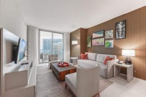 a living room with a couch and a tv at Oceanfront Lyfe Resort in Hollywood