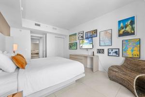 a white bedroom with a white bed and pictures on the wall at Oceanfront Lyfe Resort in Hollywood +33 photos