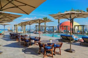 a pool with tables and chairs and umbrellas at Oceanfront Lyfe Resort in Hollywood