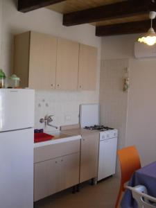 una cucina con lavandino, piano cottura e frigorifero di Delle Zagare Apartments ad Alcamo Marina