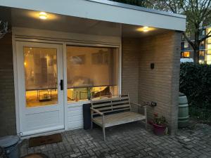 a bench sitting in front of a house at Gastensuite Eindhoven B&B Flora in Eindhoven