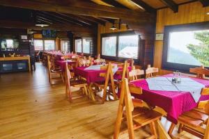 een restaurant met tafels en stoelen in een kamer bij Pensiunea Casa Ancutei in Ranca +48 foto's