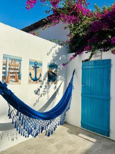 a blue hammock against a white wall with a blue door at Casa Grécia Jericoacoara in Jericoacoara