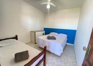 een slaapkamer met twee bedden en een plafondventilator bij Casa Vista do Sol, 5min de carro de Castelhanos, Frente Mar de Anchieta, 5 quartos-2 com ar condicionado lazer completo in Anchieta