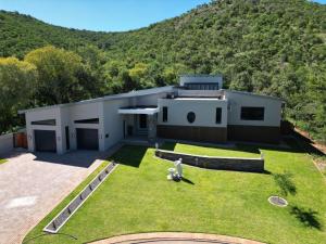 a house with a dog sitting in the yard at Thaba Bosiu Villa in Naboomspruit