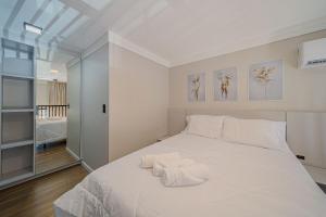 Boa VistaGarten Loft Condomínio Flipchave GLC000的卧室里有一张白色的床，床上有两条毛巾