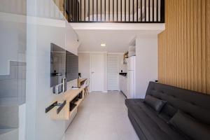 Boa VistaGarten Loft Condomínio Flipchave GLC000的带黑色沙发的客厅和厨房