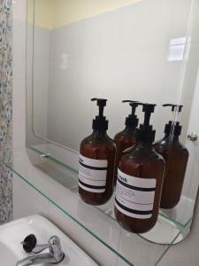 three bottles of soap sitting on a shelf in a bathroom at I'm Home Narathiwat in Narathiwat +32 photos