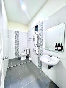 a white bathroom with a sink and a toilet at I'm Home Narathiwat in Narathiwat
