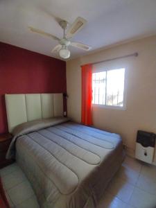 a bedroom with a large bed with a red wall at Cabañas Los Pinos in Potrero de los Funes +40 photos