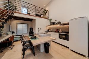 a kitchen with a table and a white refrigerator at Compact Loft Residencial Flipchave CLO000 in Boa Vista +12 photos