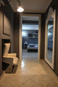 Una sala de estar con una silla y un espejo. en Casa Via Po, en Turín