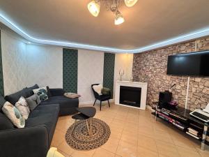 a living room with a couch and a tv at Cazare La Luiza in Şura Mare