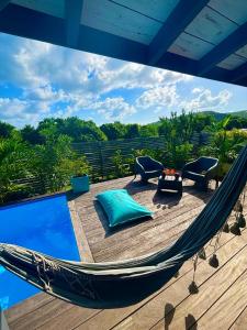 a hammock on a deck next to a pool at Bel Kay in Rivière-Salée