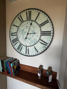 Un gran reloj en una pared encima de un estante. en Casale21, en Castiglion Fiorentino