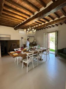 Una cocina y un comedor con mesa y sillas. en Casale21, en Castiglion Fiorentino