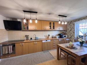 a large kitchen with wooden cabinets and a table at Cazare La Luiza in Şura Mare
