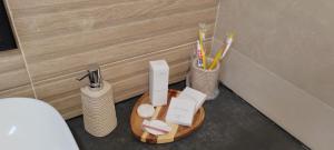 a wooden tray with toothbrushes and other items in a bathroom at Anna apartman in Niš +32 photos