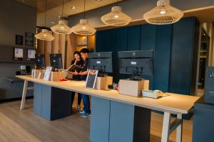 two people standing at a counter in a store at ibis Navegantes Itajai in Itajaí