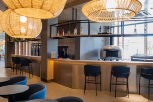 a bar in a restaurant with blue stools at ibis Navegantes Itajai in Itajaí