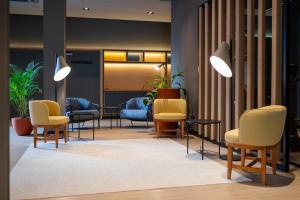 a waiting area with chairs and tables in a lobby at ibis Navegantes Itajai in Itajaí