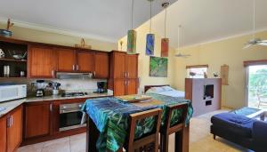 a kitchen with a table in the middle of a room at Ocean Dream High Ceiling Studio w/balcony in Cabarete