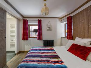 a bedroom with a large bed with red curtains at Chalet moderne avec parking et wifi, à proximité des pistes et commerces - FR-1-566-20 in Les Allues