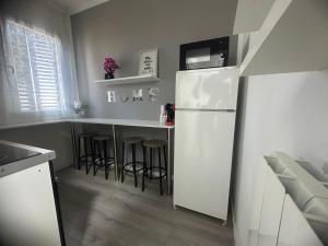 a kitchen with a white refrigerator and some bar stools at B&B Le Palme Fiera in Bologna +7 photos