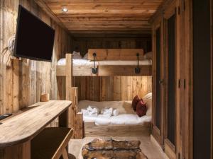 a room with two bunk beds and a flat screen tv at Chalet Méribel 12 pers, 5 ch, Animaux Admis, Parking - FR-1-566-83 in Chandon