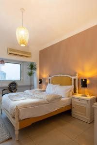 ein Schlafzimmer mit einem großen Bett und einem Kronleuchter in der Unterkunft 18th floor Nile View with Jacuzzi in Zamalek in Kairo