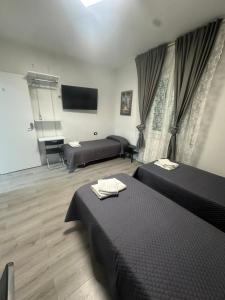 a bedroom with two beds and a flat screen tv at B&B Le Palme Fiera in Bologna