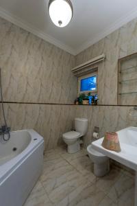 ein Badezimmer mit Badewanne, Toilette und Waschbecken in der Unterkunft 18th floor Nile View with Jacuzzi in Zamalek in Kairo + 29 Fotos