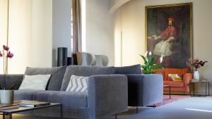 a living room with a blue couch and a painting at Locanda del lupo in Soragna