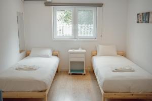two twin beds in a room with a window at Porto Window Terrace House by Vacationy in Bandeira
