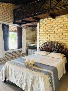 a bedroom with a large bed in a brick wall at Nordestino in Pipa