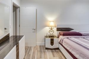 a bedroom with a bed and a table with a lamp at Work and Play! North Hills Studio 15 Mi to Hollywood in North Hills