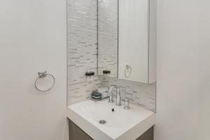 a white bathroom with a sink and a mirror at Work and Play! North Hills Studio 15 Mi to Hollywood in North Hills +17 photos