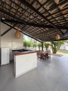 an outdoor kitchen with a bar with a table and chairs at Nordestino in Pipa