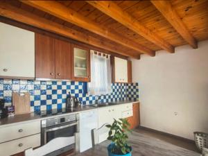 - une cuisine avec du carrelage bleu et blanc sur le mur dans l'établissement Sunset Aura Santorini, à Éxo Goniá