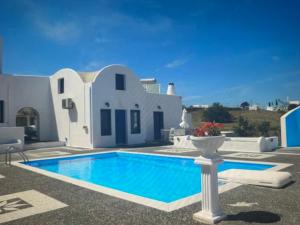 une piscine devant une maison blanche dans l'établissement Sunset Aura Santorini, à Éxo Goniá