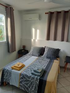 een slaapkamer met een bed met handdoeken erop bij F2 proche plage Anse Mitan in Les Trois-Îlets