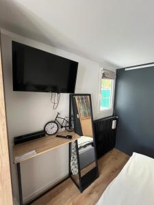 a bedroom with a desk with a large television on the wall at Ele STUDIO indépendant in Bergerac