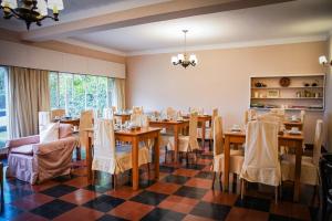 a dining room with tables and chairs on a checkered floor at Hostería La Viña in La Cumbre