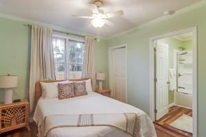 een slaapkamer met een bed en een plafondventilator bij Gulf Breeze Getaway by Next Step Property Management in Gulfport