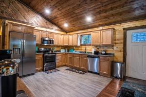 eine Küche mit Holzschränken und Geräten aus Edelstahl in der Unterkunft Forest Gap - Pizza oven, hot tub, EV charger in Hico