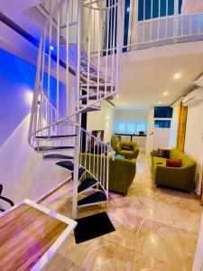 a living room with a spiral staircase in a house at Eliass Palace in Cotonou