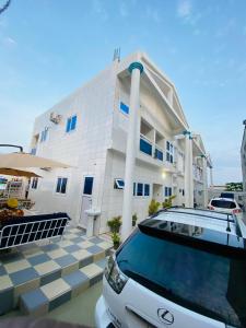 a white car parked in front of a building at Eliass Palace in Cotonou